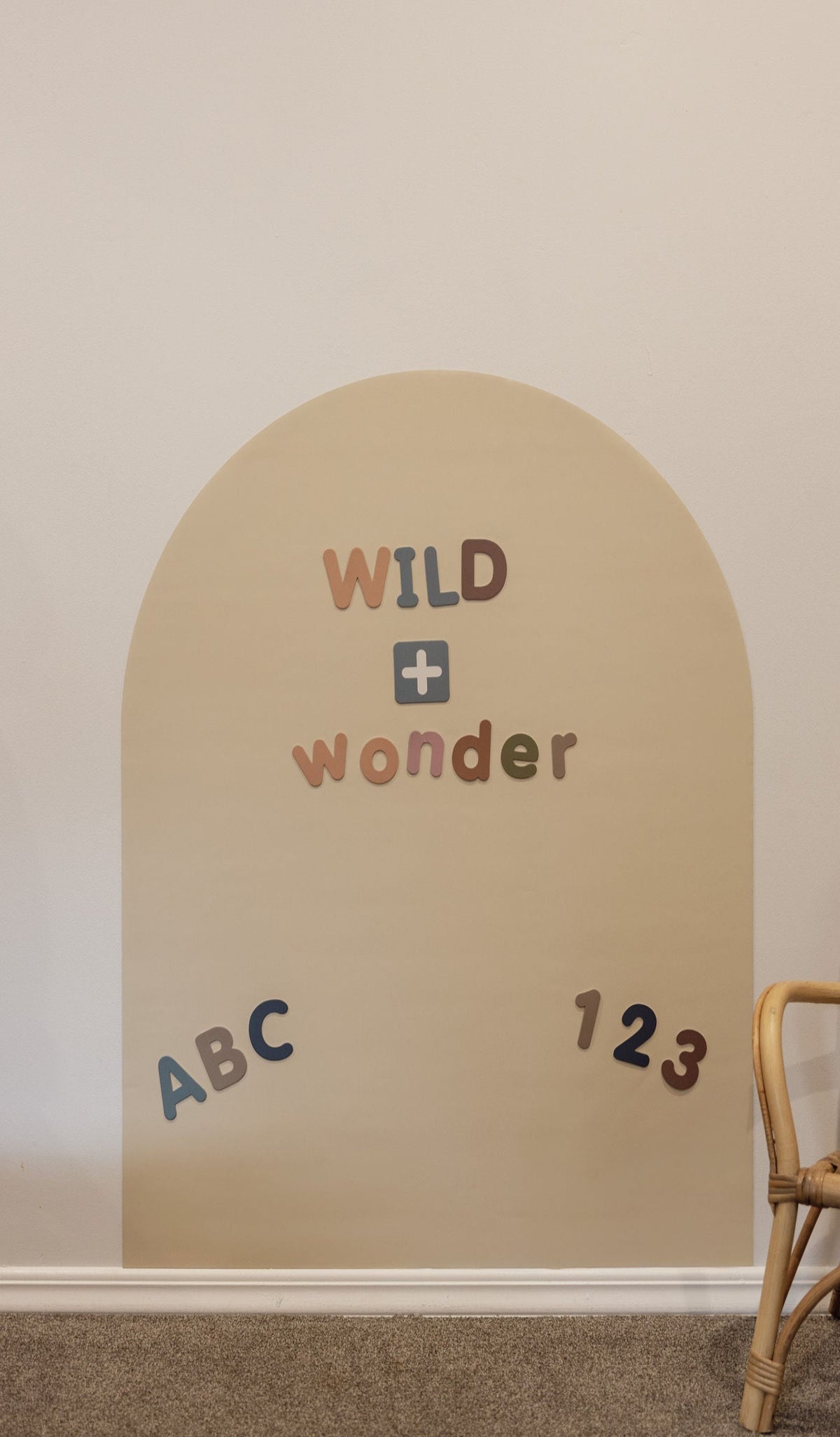 Magnetic letters spelling WILD + wonder with ABC and 123 on the Arlo Beige Wonder Arch