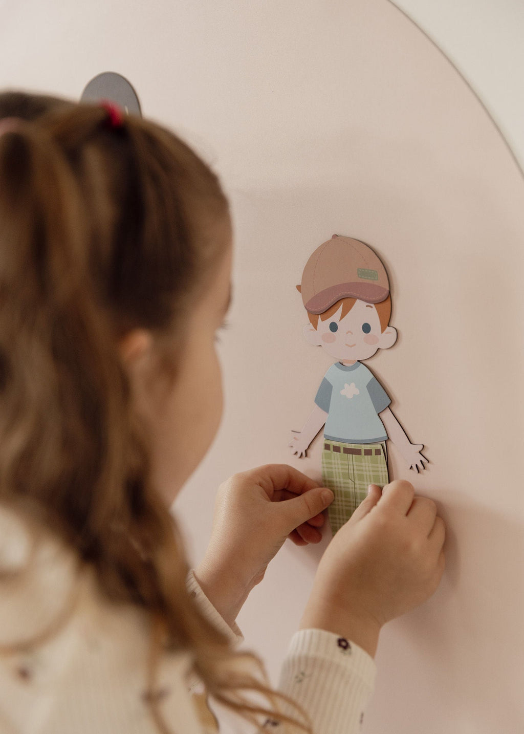Child dressing a magnetic Dressables character on the Isla Blush Wonder Arch