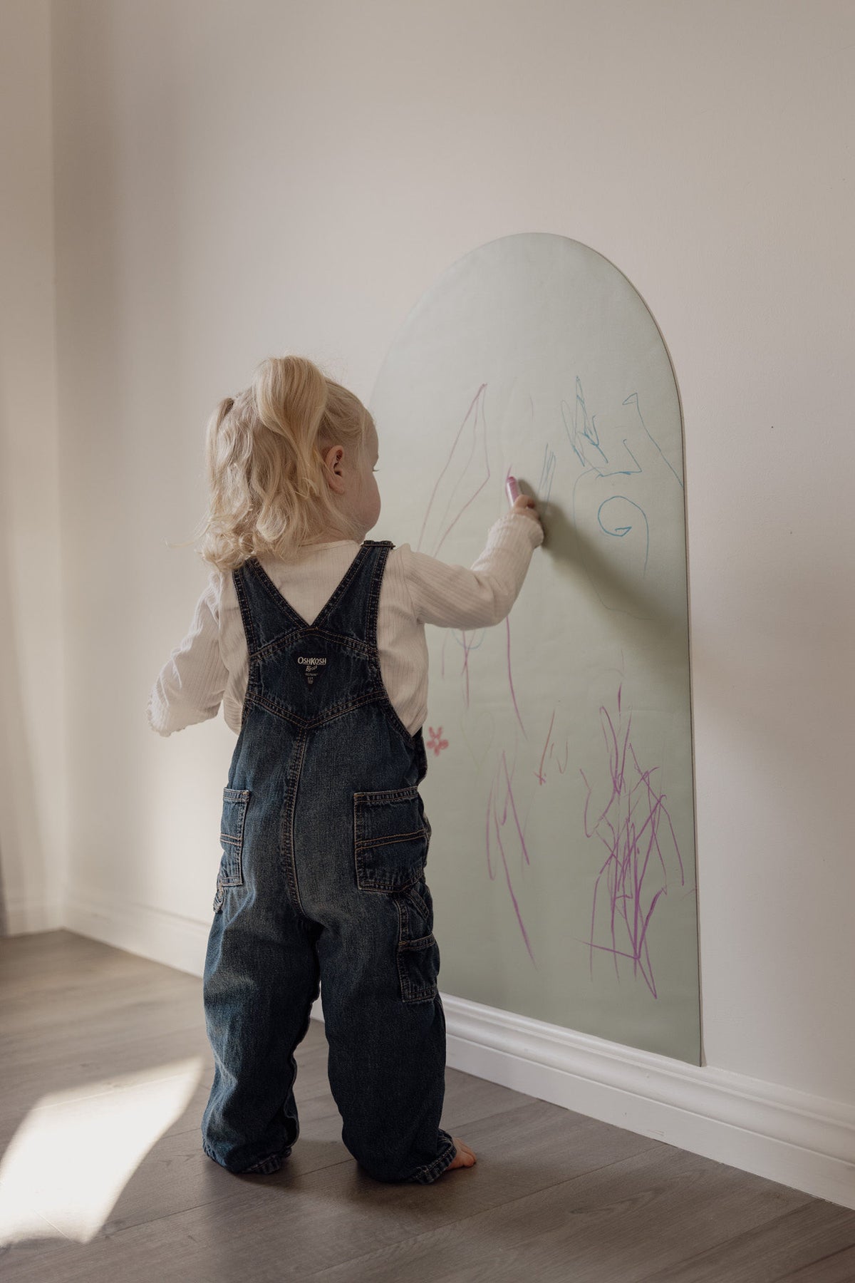 Toddler drawing with chalk on the Lily Sage Wonder Arch