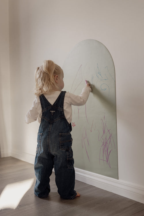 Toddler drawing with chalk on the Lily Sage Wonder Arch